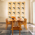 Eetkamer met houten meubelen en Elitis Art Paper behang Izu RM 1030 02 met geometrisch patroon op de achterwand.