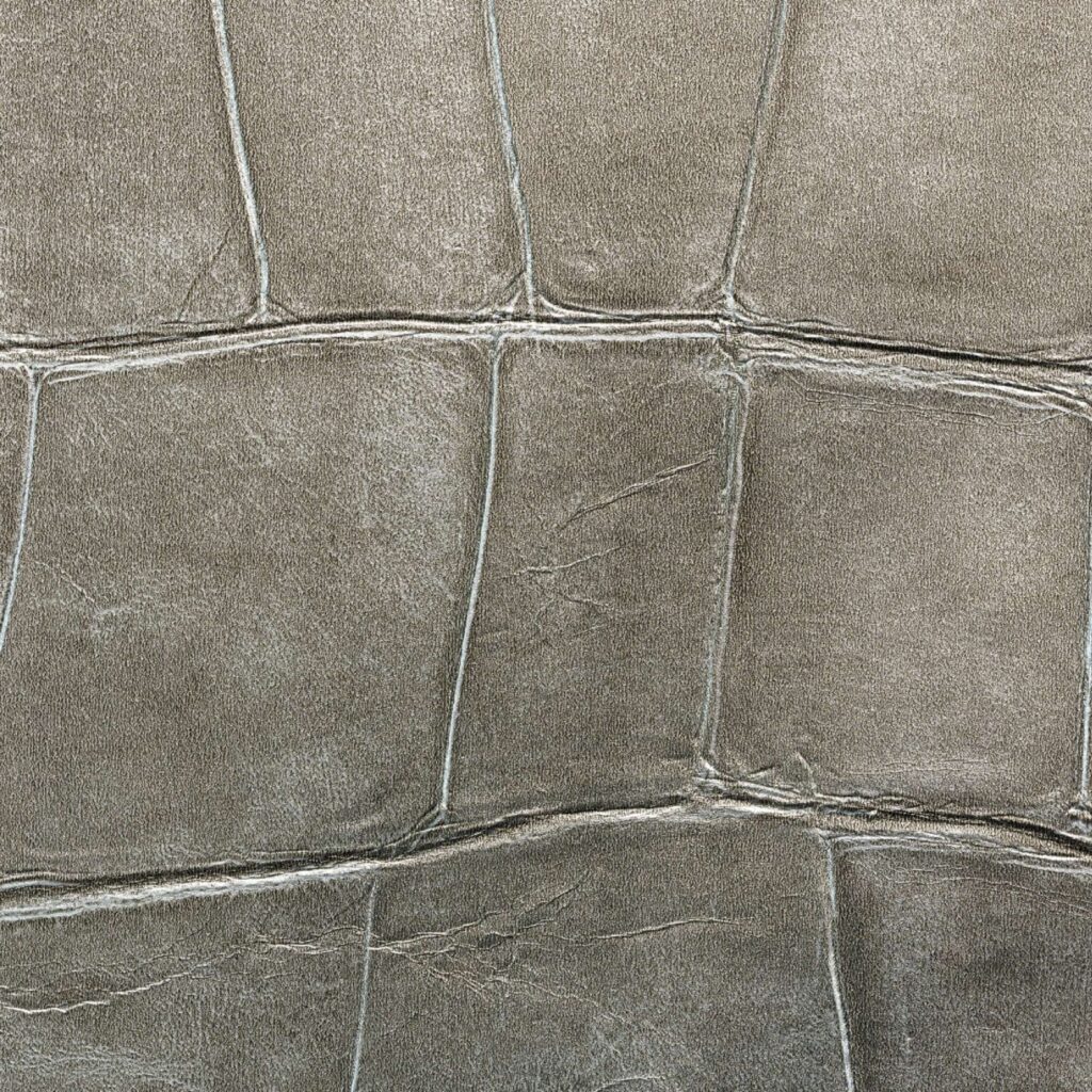 Close-up van de metallic krokodillenleerstructuur van Elitis Big Croco behang in grijstinten.