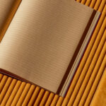 Open schrift op Elitis Colonne RM 1044 22 Rayures Jumelles behang met ribstructuur in okergeel.