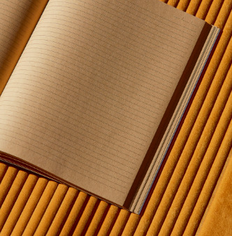 Open schrift op Elitis Colonne RM 1044 22 Rayures Jumelles behang met ribstructuur in okergeel.