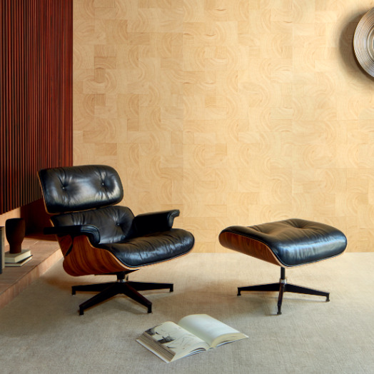 Luxe interieur met een zwarte leren Eames lounge chair en ottoman op een beige tapijt, tegen Elitis Empreintes RM 1040 15 behang uit de Marqueteries collectie.