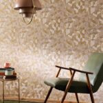 Interieur met Elitis Formentera Juego de Paja VP 717 04 behang in geometrisch stro-patroon, groene retrostoel en metalen bijzettafel.