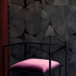 Designstoel met paarse zitting voor donker Elitis Fragments RM 1037 80 Marqueteries behang met houtpatroon.