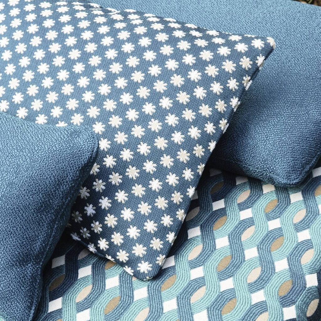 Blauwe Elitis Iseo outdoor kussens met grafische en bloemenpatronen op bijpassende gestoffeerde zitting.