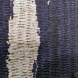 Detailopname van de textuur en kleuren van het Elitis La Casa Azul wandbekledingsmateriaal.