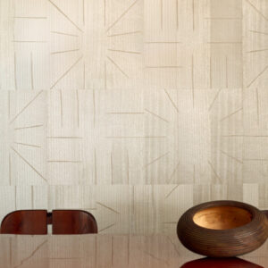 Beige Elitis Le Roi Soleil behang met geometrisch zonnestraalpatroon in een modern ingerichte eetkamer.