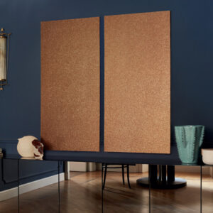 Twee grote panelen met Elitis Nacres Metal VP 949 93 wandbekleding hangen aan een donkerblauwe muur in een stijlvol interieur.