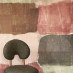 Detail van Elitis Palette VP 964 01 Atelier d’Artiste behang met abstracte kleurvlakken en een moderne, donkergroene designstoel op de voorgrond.