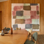 Moderne eetkamer met Elitis Palette VP 964 01 behang in abstracte kleurvlakken tegen een houten lambrisering.