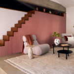 Moderne interieursetting met Elitis Pilastre RM 1043 51 Rayures Jumelles behang als trapbekleding en wanddecoratie.