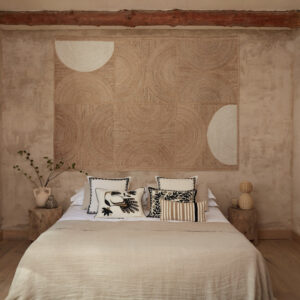 Sfeervolle slaapkamer met een Elitis Rockey vloerkleed in crèmekleur aan de muur als wanddecoratie.