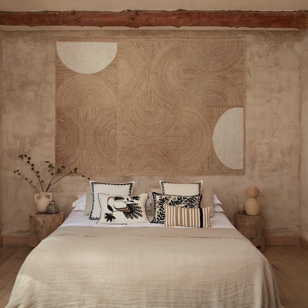 Sfeervolle slaapkamer met een Elitis Rockey vloerkleed in crèmekleur aan de muur als wanddecoratie.