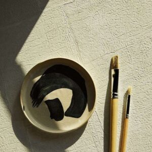 Beige Elitis Sangpi VP 1018 60 behang met voelbare textuur, naast een penseelbord en twee kwasten.