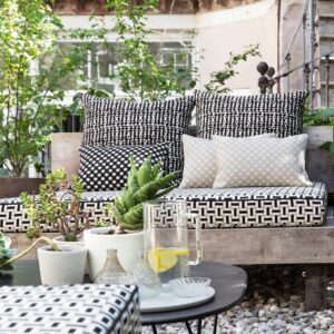 Stijlvol ingerichte tuinlounge met Elitis Sebino outdoor kussens in zwart-witte geometrische patronen.