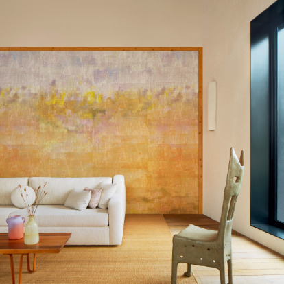 Stijlvol interieur met Elitis Solstice VP 966 01 behang in zachte pasteltinten, een witte bank en artistieke details.