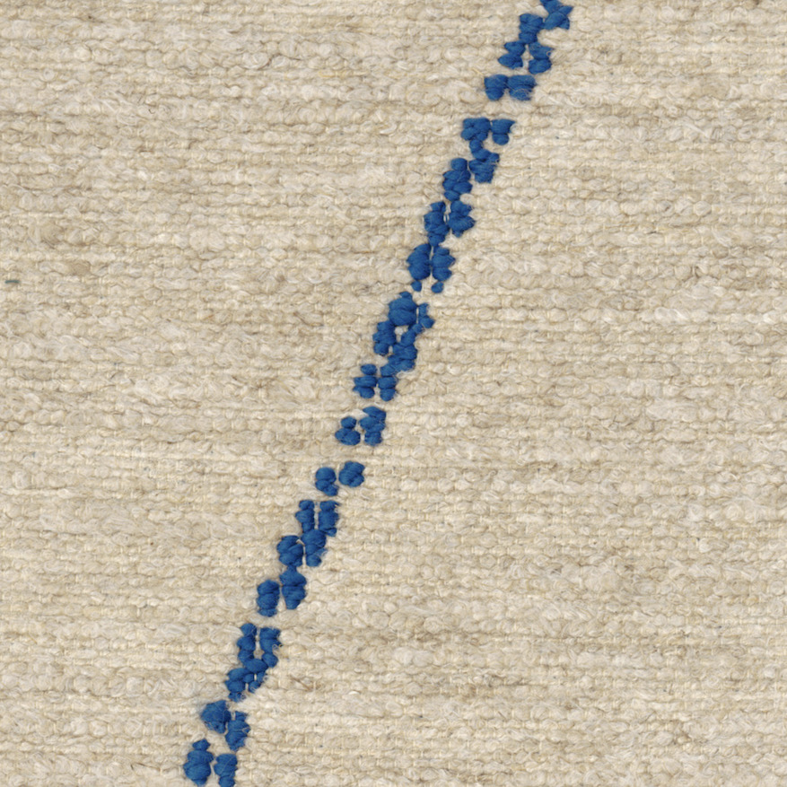 Detail van Elitis Tampico-stof LR 355 41 met grove beige textuur en diagonale blauwe borduurlijn.