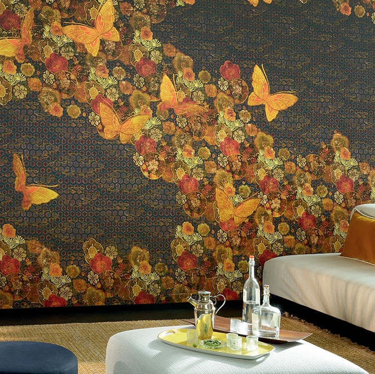 Sfeervolle woonkamer met een wandbekleding uit de Elitis-collectie "Une histoire de paradis", met kleurrijke bloemen en gele vlinders op een donkerblauwe achtergrond.
