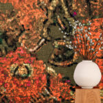 Witte vaas met sierlijke takken op een houten blok, voor Elitis Zakinthos VP 956 01 panorama behang met warm bloemenpatroon.