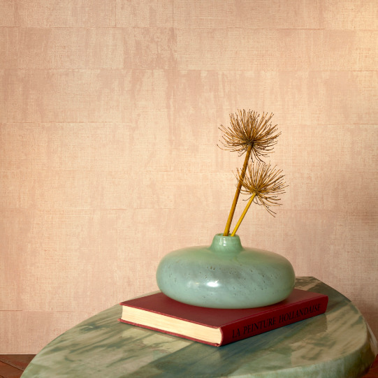 Groene vaas met gedroogde bloemen op een rood boek op een marmeren tafel, voor Elitis Atelier d'artiste VP 880 53 behang.