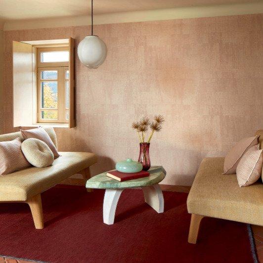 Sfeervolle woonkamer met Elitis Atelier d'artiste VP 880 53 behang, beige zitmeubels en een ovale salontafel.
