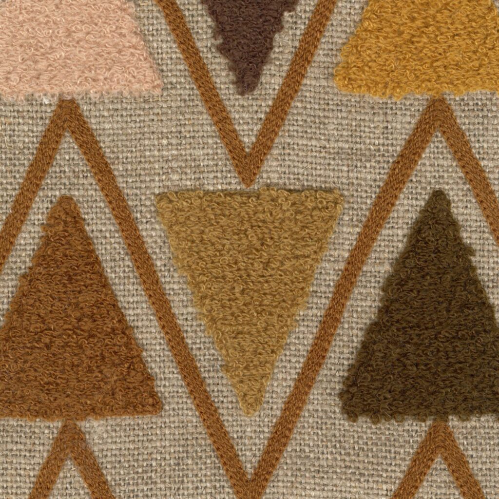 Detail van het Elitis Baleares Joya LZ 904 22 textiel met kleurrijke, getufte driehoeken op een beige geweven achtergrond.