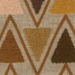 Detail van het Elitis Baleares Joya LZ 904 22 textiel met kleurrijke, getufte driehoeken op een beige geweven achtergrond.
