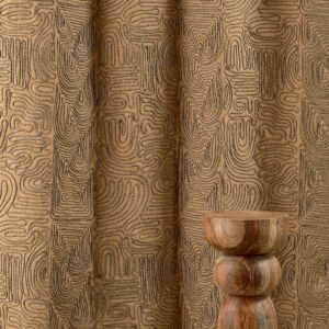 Beige Elitis Baleares Llenya LZ 905 01 gordijn met abstract patroon en houten decoratief object op de voorgrond.