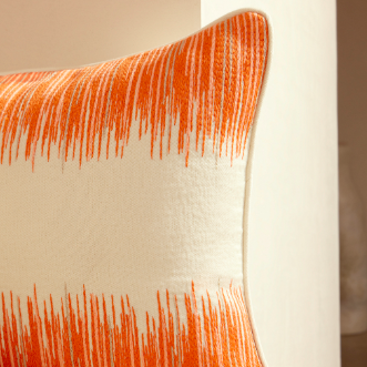 Detail van het Elitis Basile sierkussen met oranje en witte grafische patronen.