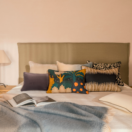 Sfeervol gedecoreerd bed met het Elitis Basile CO 257 89 02 sierkussen en andere decoratieve kussens.