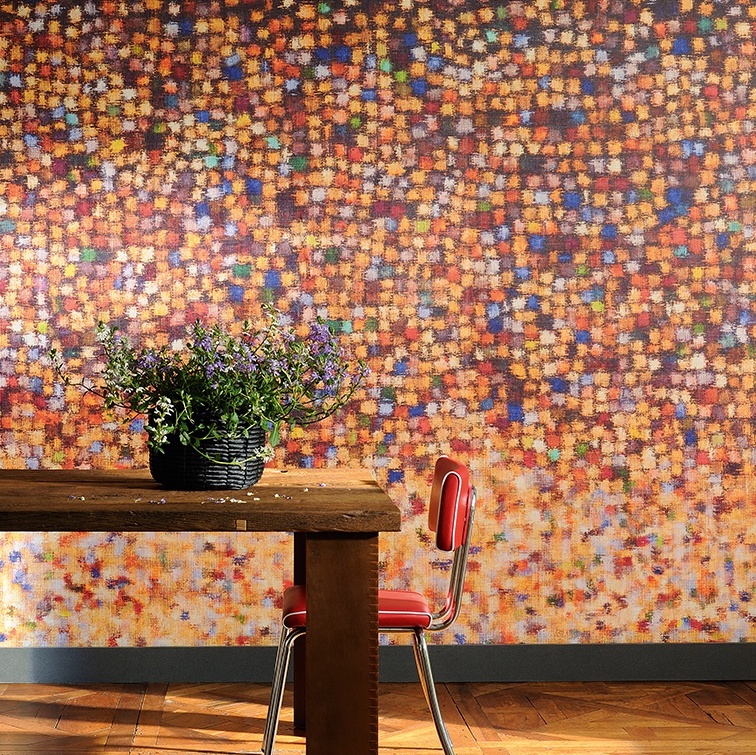 Houten tafel met bloemen in een zwarte mand voor kleurrijk Elitis-behang met pixelachtig patroon uit de serie "A big splash".