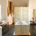 Luxe badkamer met marmeren bad en Elitis Art Paper Jimq RM 1033 01 behang op de achterwand.