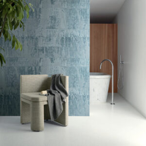 Modern interieur met Elitis-behang uit de Atelier d'artiste collectie, een marmeren bad, designstoel en blauwe accentmuur.