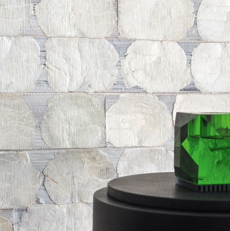 Detail van Elitis-behang Ecrin Puerto Princesa met glanzende, ronde parelmoerachtige vlakken en een groene glazen decoratie op een zwarte zuil.