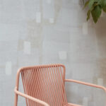 Roze designstoel voor Elitis-behang Espiritu TP 329 01 uit de Voile de Papier collectie met abstract patroon.