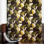 Bloemenbehang Elitis Flower Power Arum TP304 met grote witte en gele aronskelken op een donkere achtergrond.