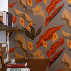 Behang met kleurrijk blad- en bloemmotief uit de Elitis Flower Power Fleur de lune collectie tegen een grijze achtergrond.