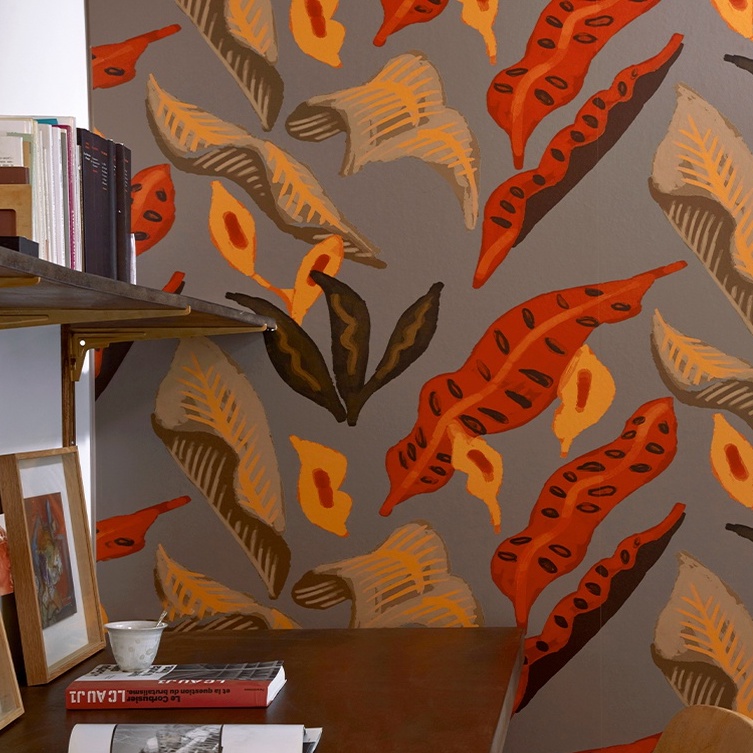 Behang met kleurrijk blad- en bloemmotief uit de Elitis Flower Power Fleur de lune collectie tegen een grijze achtergrond.