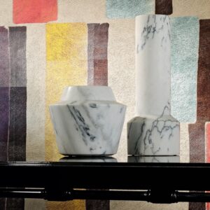 Twee marmeren designvazen op een zwarte tafel voor een kleurrijk Elitis Indomptee Tribeca VP 617 01 behang.