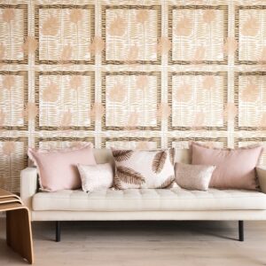 Beige bank met roze kussens tegen een decoratieve Elitis Initiation Mantra TP 314 03 behangmuur met bladerpatroon.