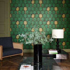 Moderne woonkamer met Elitis-behang Initiation Totem in groen en goud als opvallende achtergrond.