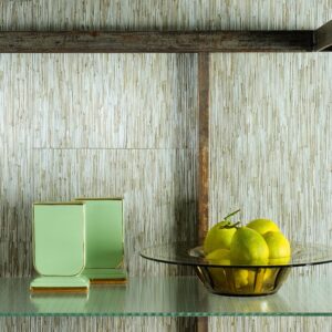 Glazen schaal met citroenen en groene vazen op een plank tegen Elitis-behang La Casa de Paja.