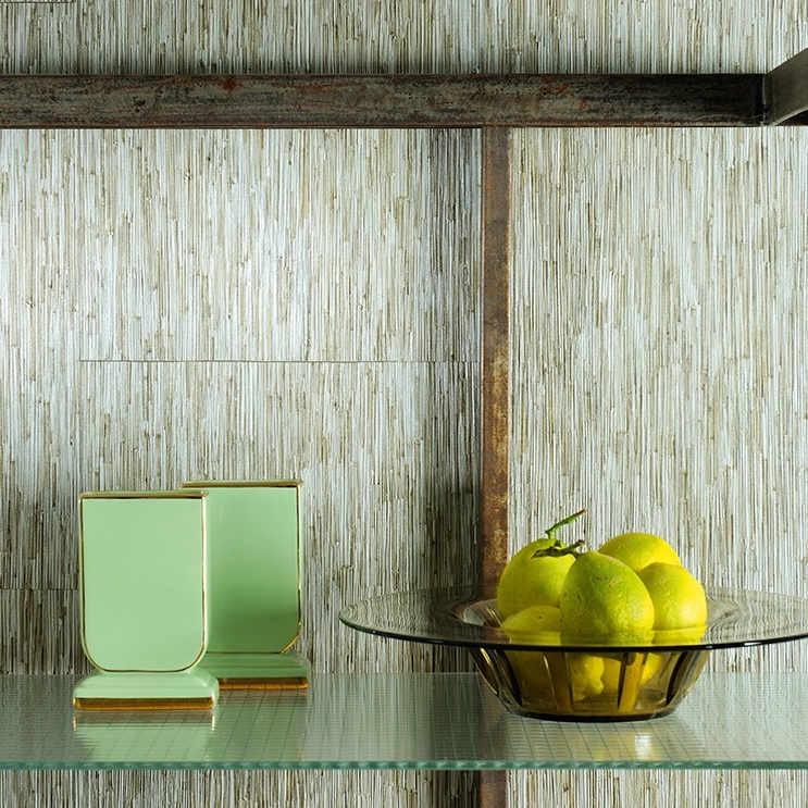 Glazen schaal met citroenen en groene vazen op een plank tegen Elitis-behang La Casa de Paja.