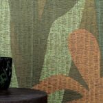Detail van het Elitis-behang 'La passion de Diego' met een botanisch motief in aardetinten en textuur.