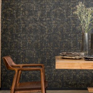 Modern interieur met Elitis-behang Laca Salvaje in donker goud-zwart patroon, gecombineerd met houten meubelen en aardewerken decoratie.