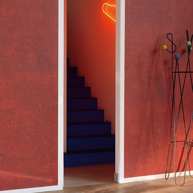 Deur met zicht op blauwe trap en rood Elitis-behang "L'écoute du silence mythique", met neon hart en metalen kapstok.