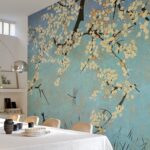 Behang met kersenbloesemtakken en libellen op een blauwe achtergrond siert een moderne eetkamer.