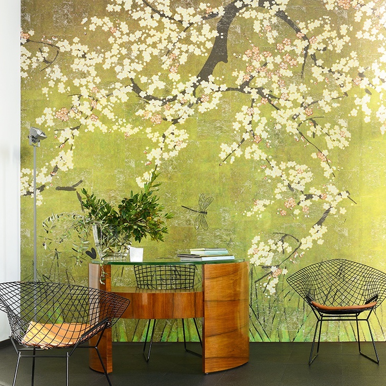 Modern interieur met houten bureau en Elitis-behang 'Les cerisiers sauvages' met bloesemtakken op een groene achtergrond.