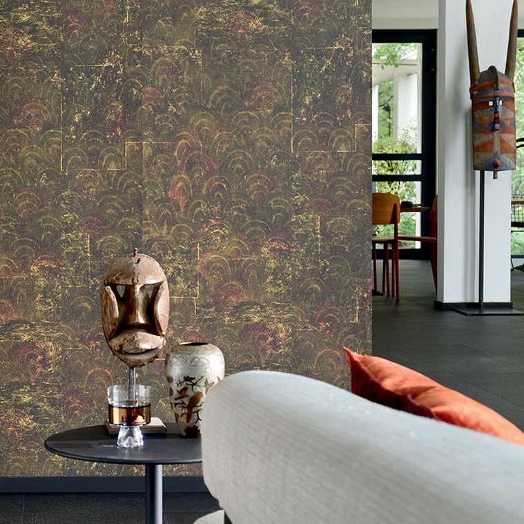 Woonruimte met Elitis-behang 'L'infime et l'infini' in warme, donkere tinten en decoratieve objecten op een bijzettafel.
