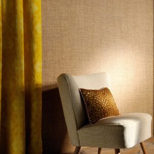 Luxe Elitis-behang uit de Madagascar-collectie met een beige textuur, naast een lichtgrijze stoel en gele gordijnen.