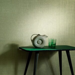 Moderne setting met Elitis-behang Madagascar 5, een groene tafel, een designkan en twee groene glazen.